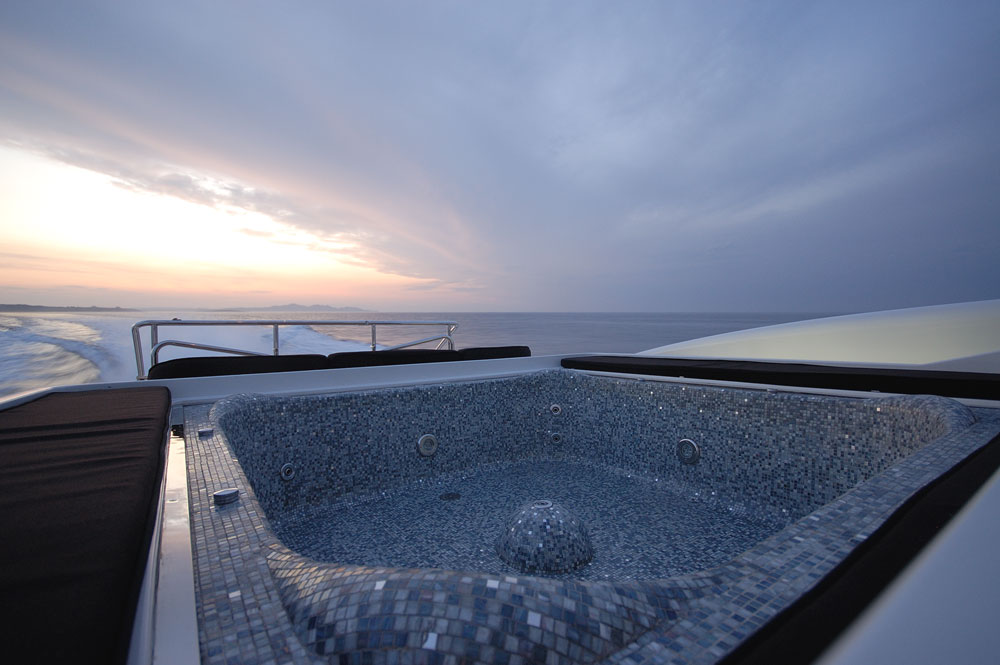 Vista dalla poppa della piscina idromassaggio vuota con mosaico sullo yacht Mangusta 108' ARES all’alba